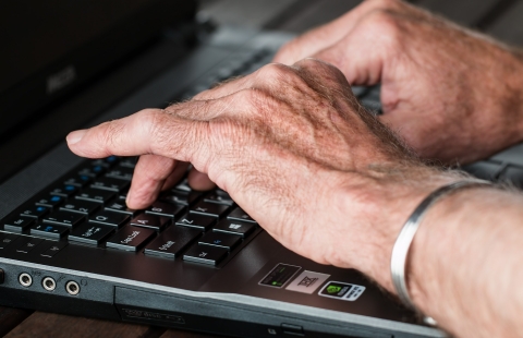 A photo of hands typing on a laptop