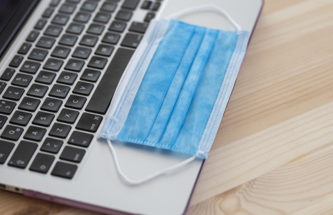 Photo of a surgical mask on a laptop