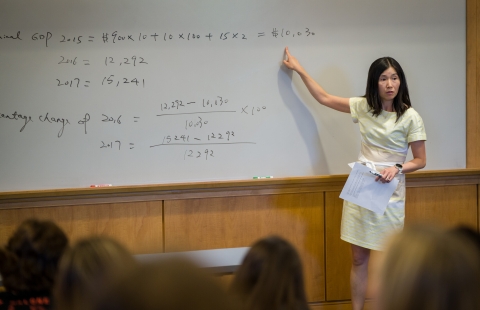 A female Asian professor lectures to college students