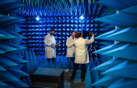 Three researchers in a room with walls lined with blue pointed foam