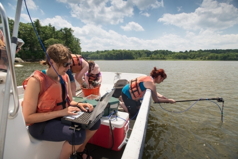 College students collecting research data on a river