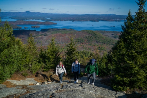 Three college students climbing a mountain
