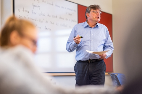 College professor standing in front of a white board