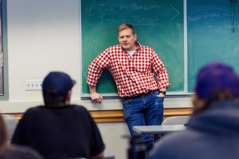professor at chalk board in classroom